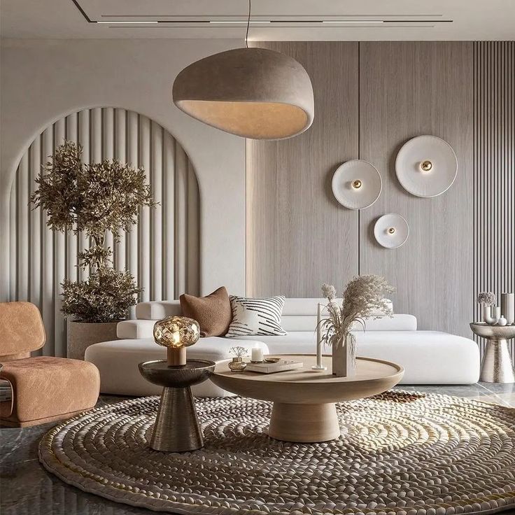 Soft, beautiful living room with neutral colours, circular coffee tables, white couch and velvet brown sofa chairs, and shell beige lamp knit carpet.